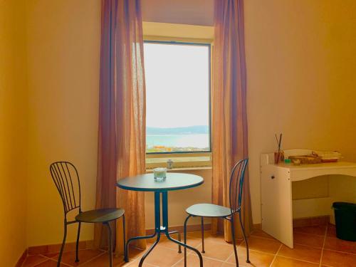 a table and chairs in a room with a window at Artis Mare in Pozzuoli