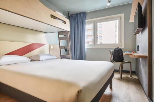 a hotel room with a large bed and a window at ibis budget Paris Porte d'Aubervilliers in Aubervilliers