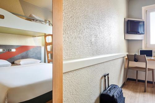 a room with two bunk beds and a tv at ibis budget Paris Porte d'Aubervilliers in Aubervilliers
