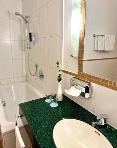 a bathroom with a sink and a bath tub and a sink at Landhotel Stegersbach in Stegersbach