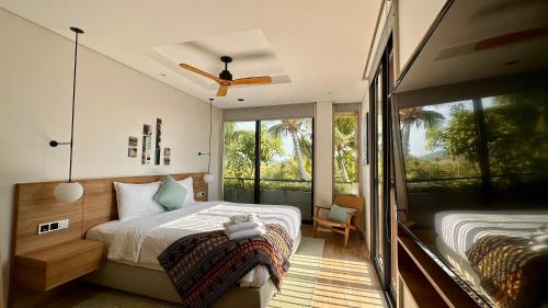 a bedroom with a bed and a large window at West Phu Quoc Charm 3BR private pool villa in Phu Quoc