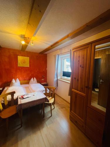 a bedroom with two beds and a table and a window at Pension Bucher in Schnann