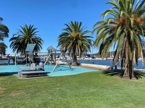 a playground with palm trees next to the water at Gosfords Best Location with Views in Gosford