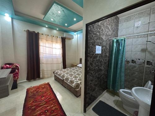 a bathroom with a bed and a shower and a sink at Petra View Flat in Wadi Musa