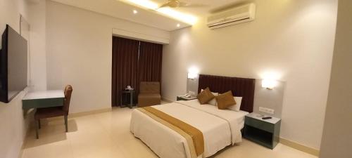 Habitación de hotel con cama y escritorio en White Orchid, en Cox's Bazar