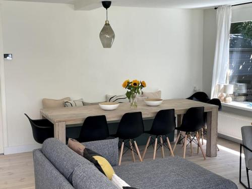 a living room with a table and a couch at Modern beach house for 12 pers! With jacuzzi in Julianadorp
