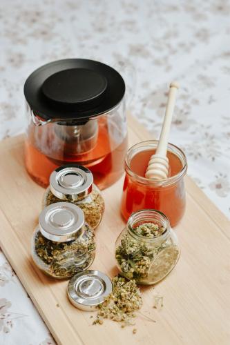 a wooden cutting board with a jar of pickles and a jar of jam at Apartments Čenda in Železniki