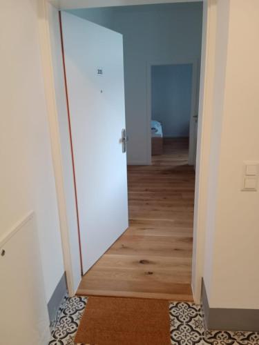 a hallway with a white door and a wooden floor at Krems am Campus in Krems an der Donau