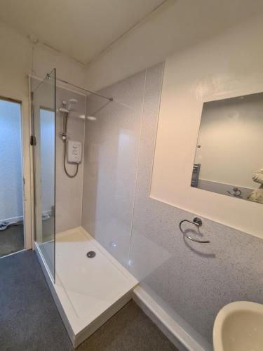 a bathroom with a glass shower and a sink at North Face Apartment , Fort William in Torlundy