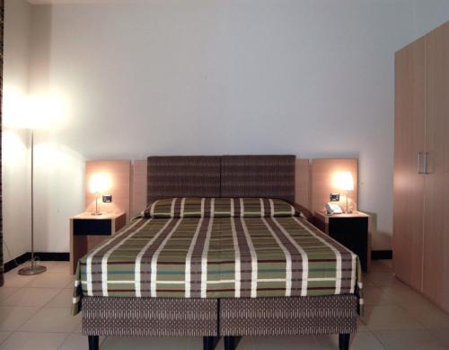 a bedroom with a large bed with two night stands at Hotel Santo Stefano in Pieve Santo Stefano