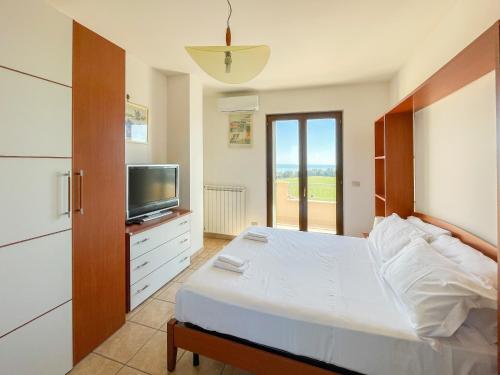 a bedroom with a large bed and a television at Homiday - Villa Mila in Pineto