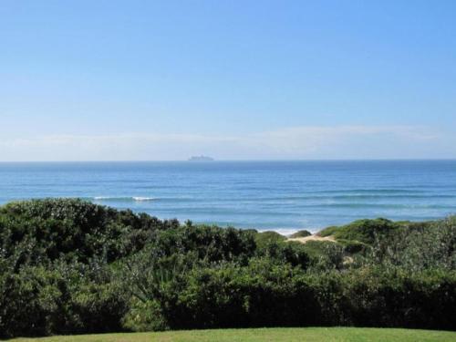 a view of the ocean with a ship in the distance at The Spinning Reel Beach Cottages in Port Alfred