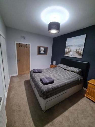 a bedroom with a bed and a blue wall at North Face Apartment , Fort William in Torlundy