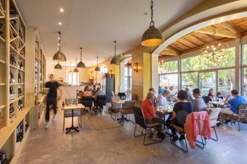 um grupo de pessoas sentadas em mesas em um restaurante em Le Château Olive et Raisin em Fontaine-de-Vaucluse