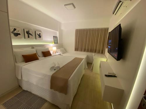 Cette chambre comprend un grand lit et une télévision. dans l'établissement Ap Cumbuco 04 BEACH PLACE - mobiliado e completo a 200m da praia, à Cumbuco