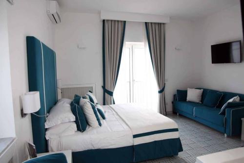 Habitación de hotel con cama y sofá azul en Hotel Bristol en Vietri