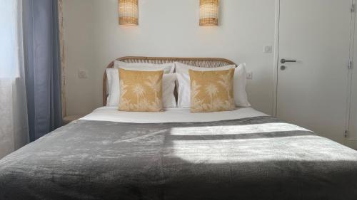 a bed with white sheets and pillows in a bedroom at Jardin Bleu - Chambres d'hôtes in Saint-Girons