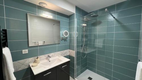 a bathroom with a sink and a shower with a mirror at Jardin Bleu - Chambres d'hôtes in Saint-Girons