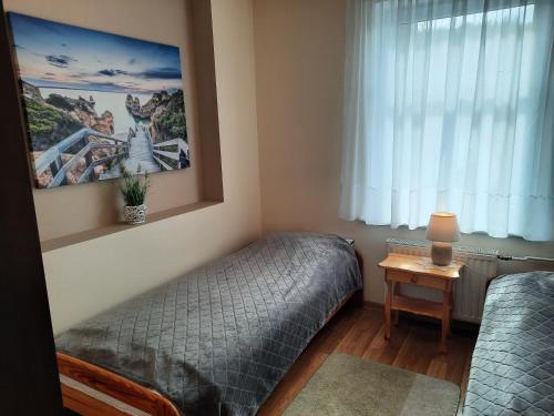 1 Schlafzimmer mit 2 Einzelbetten und einem Fenster in der Unterkunft Apartament na Skarpie in Wrzeszczyn