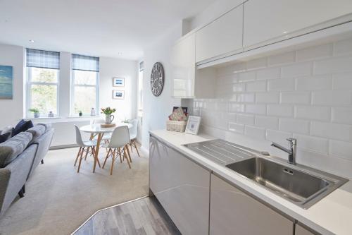 a white kitchen with a sink and a table at Host & Stay - Number 2 at Pannett Apartments in Whitby