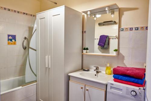 une salle de bain avec un lavabo et une douche dans l'établissement Plein coeur Plein soleil, à Sète