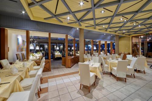 a dining room with white tables and white chairs at Hotel Bredeney in Essen