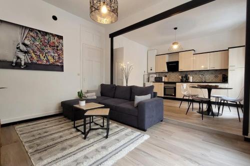 un salon avec un canapé bleu et une cuisine dans l'établissement Hypercentre Chambéry, à Chambéry