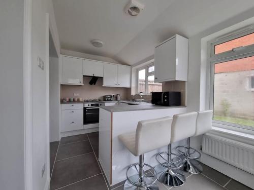 a kitchen with white cabinets and white counter tops at A Beautiful Premium 4-Bedroom House With Parking (Reading West) in Reading