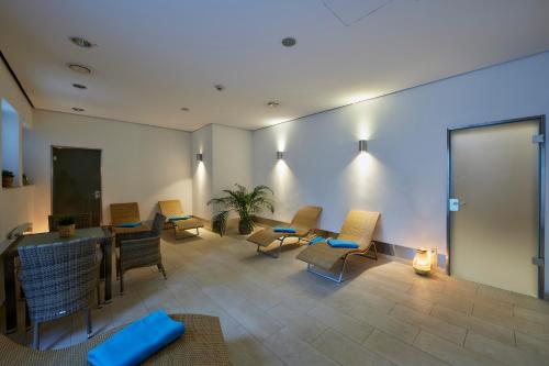 a waiting room with chairs and a table and a screen at Hotel Bredeney in Essen