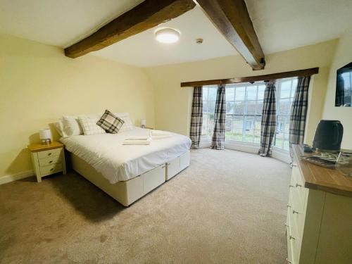 a bedroom with a bed and a large window at The Royal Oak in Tewkesbury