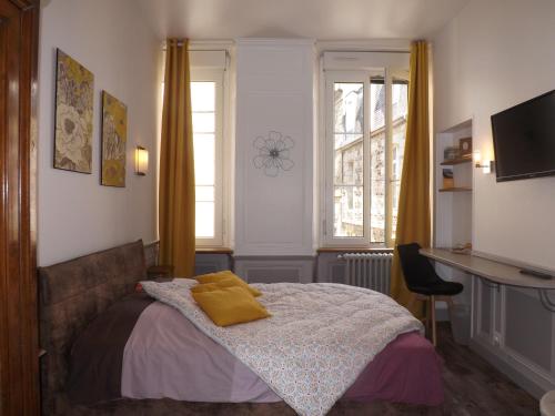 a bedroom with a bed with yellow pillows on it at Chambre d'hôtes LARIBOISIERE in Fougères