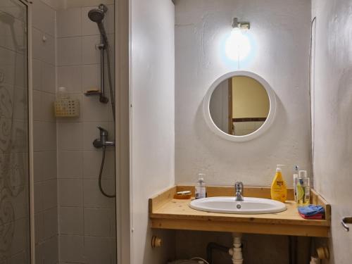 een badkamer met een wastafel, een spiegel en een douche bij vue exceptionnelle sur les canaux in Sète