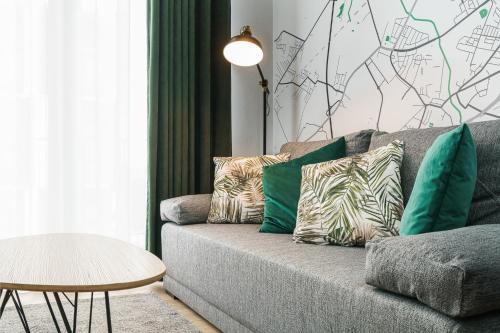 a living room with a couch with pillows and a table at RentPlanet - Apartamenty Zarembowicza II in Wrocław