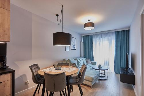 eine Küche und ein Wohnzimmer mit einem Tisch und einem Sofa in der Unterkunft Apartamenty Świnoujście - Sun Towers 90 in Świnoujście