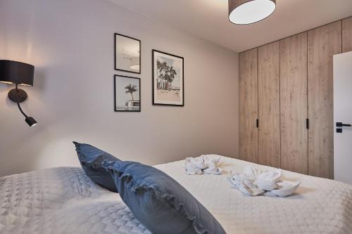 a bedroom with a white bed with blue pillows at Apartamenty Świnoujście - Sun Towers 90 in Świnoujście