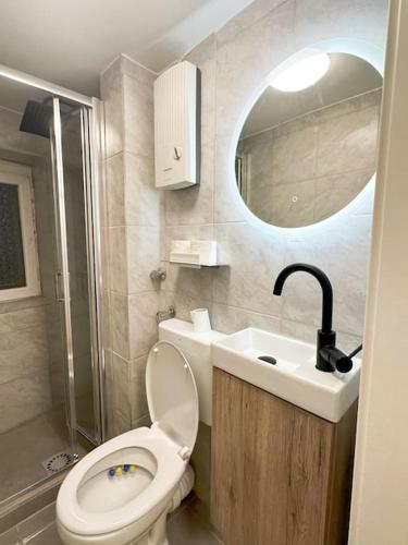 a bathroom with a toilet and a sink and a mirror at Micro Appartement hbf 7min in Duisburg