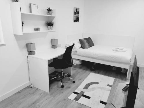 a bedroom with a desk and a bed and a desk chair at Studio apartment within city centre with ensuite in Coventry