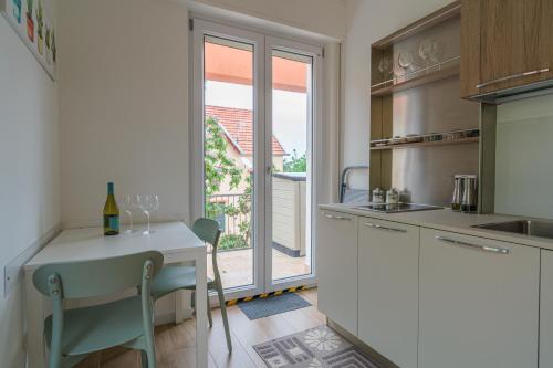una cocina con una mesa pequeña y una ventana en Casa Lighea Mondello, en Mondello