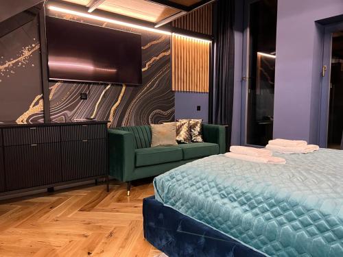 a bedroom with a bed and a couch and a flat screen tv at LUX 114 APARTMENT in Košice