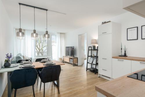 een keuken en een woonkamer met een tafel en stoelen bij SHINY HOMES - City Center with Parking Place in Gütersloh
