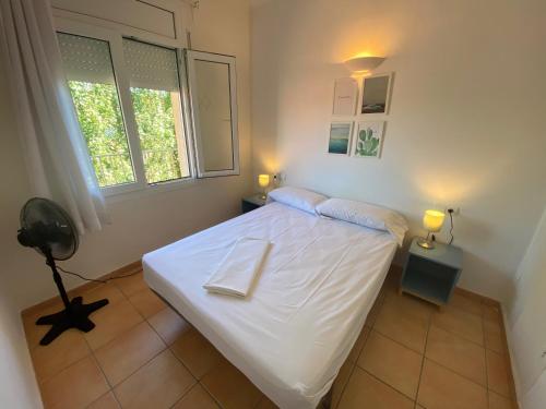 een slaapkamer met een wit bed en 2 ramen bij Mare Nostrum 543 in Torroella de Montgrí