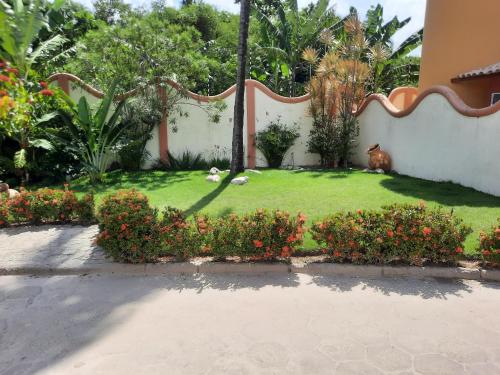 a yard with a dog sitting on the grass at Vila Santa Fé in Porto Seguro