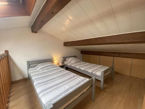 une chambre avec deux lits dans un grenier dans l'établissement Studio mezzanine à 50m de la plage, 5 couchages, parking - FR-1-226-490, à Sainte-Maxime