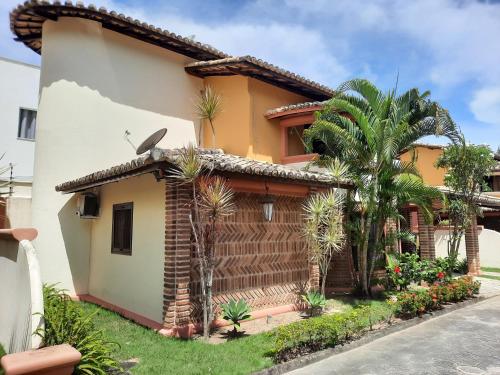 a house with palm trees in front of it at Vila Santa Fé in Porto Seguro