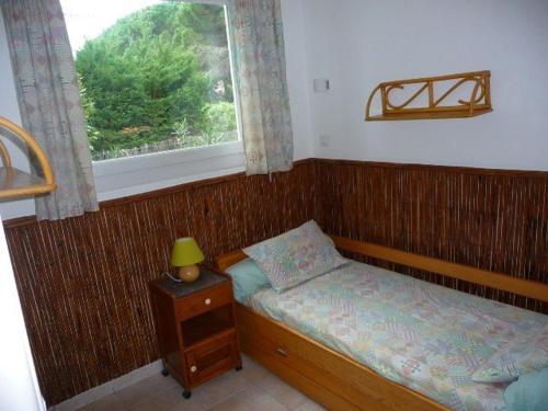 une petite chambre avec un lit et une fenêtre dans l'établissement Appartement T2 pour 4 personnes, proche plage et commerces, jardin privé, parking, animaux acceptés - FR-1-226B-111, à Cavalaire-sur-Mer