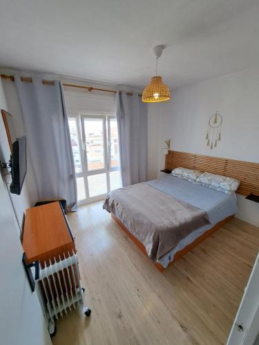 a bedroom with a bed and a television and a table at Precioso apartamento en L'hospitalet de l'infant in Hospitalet de l'Infant