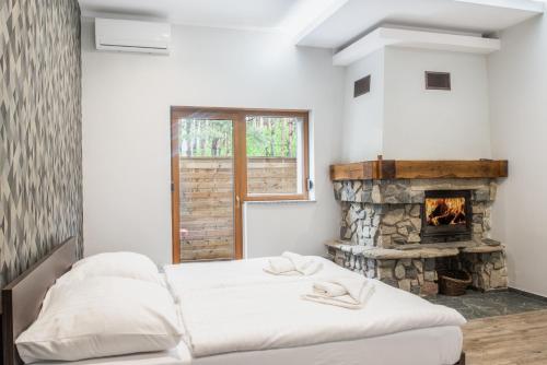 2 łóżka w pokoju z kominkiem w obiekcie Resort Pod Lasem w mieście Kolonowskie