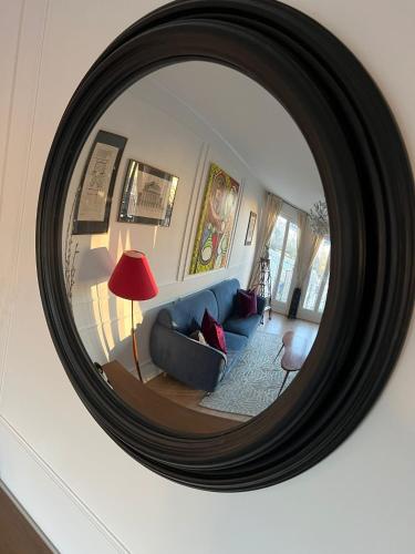 un miroir reflétant un salon avec un canapé bleu dans l'établissement The Peregrines Nest, à Reims