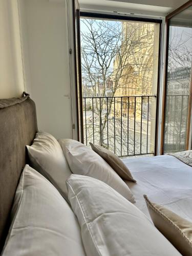 - un lit avec des oreillers assis devant une fenêtre dans l'établissement The Peregrines Nest, à Reims