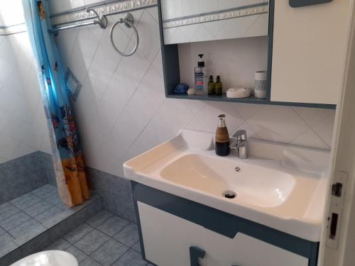 ein Bad mit einem Waschbecken und einer Dusche in der Unterkunft Sunrise View House in Poros